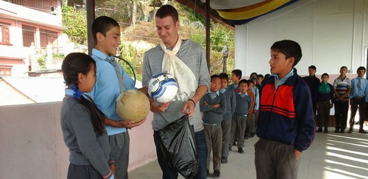 Jerome giving a ball to school 